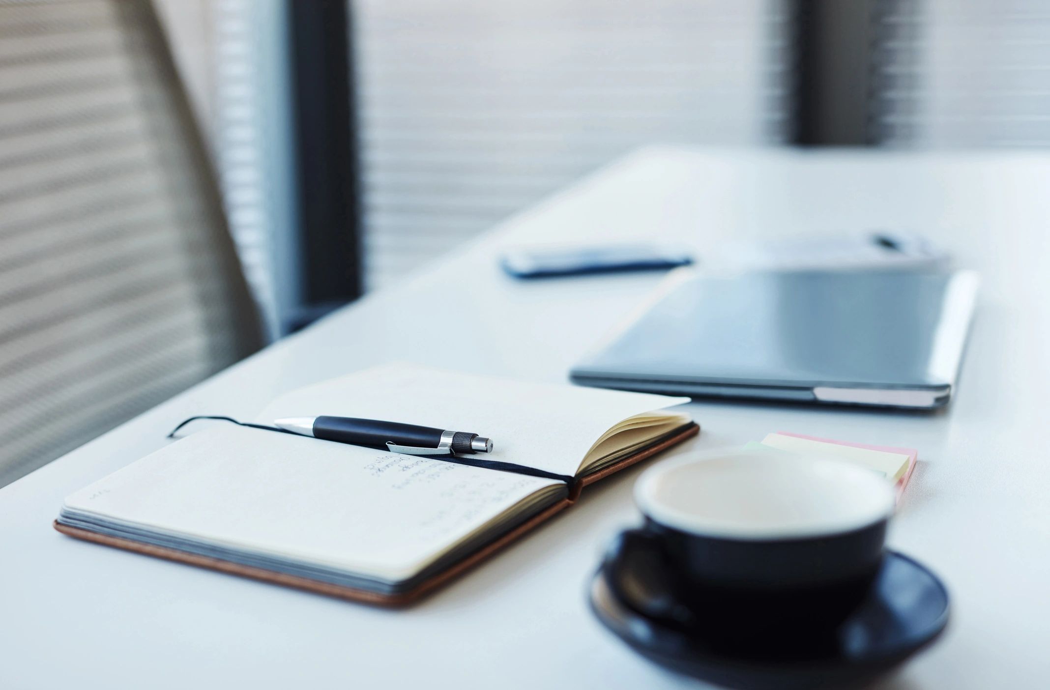 Notebook and laptop on a desk, representing an author workspace